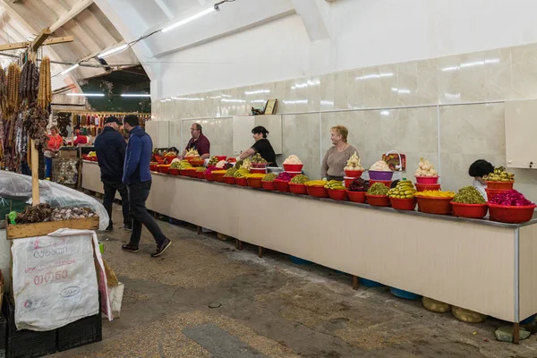 Verkäufer salziger Lebensmittel stehen und sitzen an ihren Schaltern auf dem Markt in der Altstadt von Kutaisi in Georgien — Stockfoto