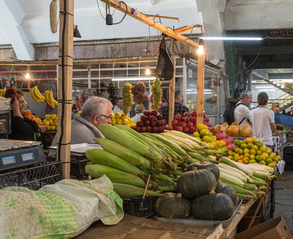 Venditore di frutta e verdura fresca si siede al suo bancone nel mercato nella parte vecchia di Kutaisi in Georgia — Foto Stock
