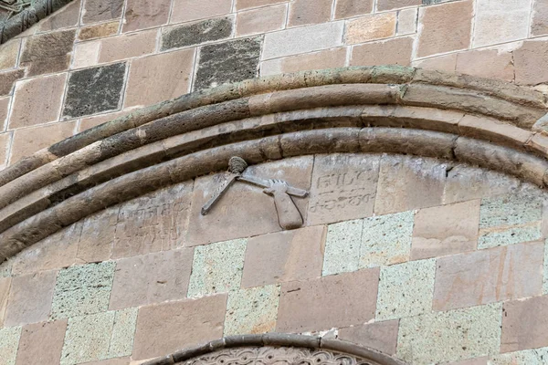 Bas-relief ręka z kilofem - symbol budowniczych na zewnętrznej ścianie katedry Sweticchoweli w mieście Mccheta w Gruzji — Zdjęcie stockowe