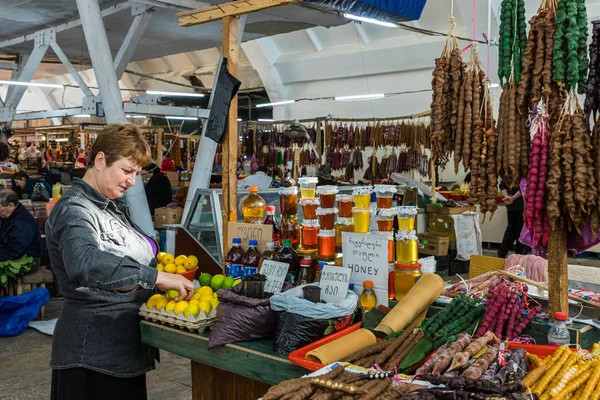 Venditore di cibo si trova vicino al suo bancone nel mercato nella parte vecchia di Kutaisi in Georgia — Foto Stock