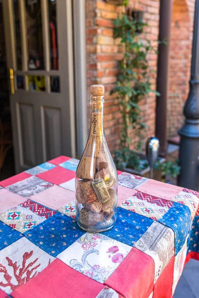 Uma garrafa de vinho cheia de cortiça está sobre a mesa em Ioane Shavteli St, na cidade de Tbilisi, na Geórgia — Fotografia de Stock