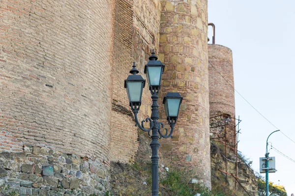 Decoratieve ijzeren straatlamp staat vlakbij de muren van fort Narikhala op de heuvel Narikhala in Tbilisi stad in Georgië — Stockfoto