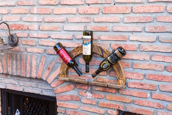 Publicité décorative de bouteilles de vin vides et un verre sur le mur d'un restaurant géorgien sur la rue Samghebro dans la ville de Tbilissi en Géorgie — Photo