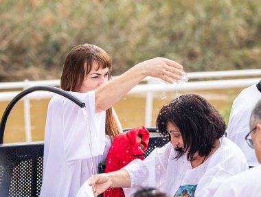 İnananlar, sevinçle birbirlerine Ürdün Nehri 'nden kutsal su serpin. İsrail' deki Jericho yakınlarındaki Ürdün Nehri üzerindeki İsa 'nın Vaftiz Alanı' na.