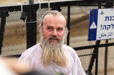 Epifani ayinine gelen inananlar, İsrail 'deki Jericho yakınlarındaki İsa Mesih' in Vaftiz Alanı 'ndaki Ürdün Nehri' nden abdestini almak için Kutsal Su 'yu kullanıyorlar.