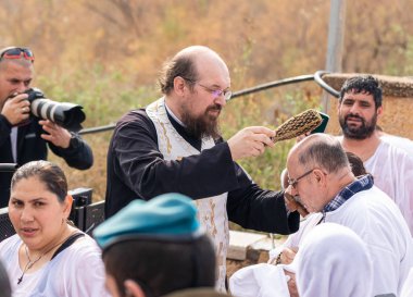 Rahip, İsrail 'deki Jericho yakınlarındaki Ürdün Nehri' ndeki İsa Mesih 'in Vaftiz Alanı' nda vaftiz törenini yapıyor.
