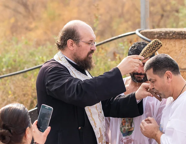 El sacerdote hace el rito del bautismo en el sitio bautismal de Jesucristo en el río Jordán cerca de Jericó en Israel — Foto de Stock