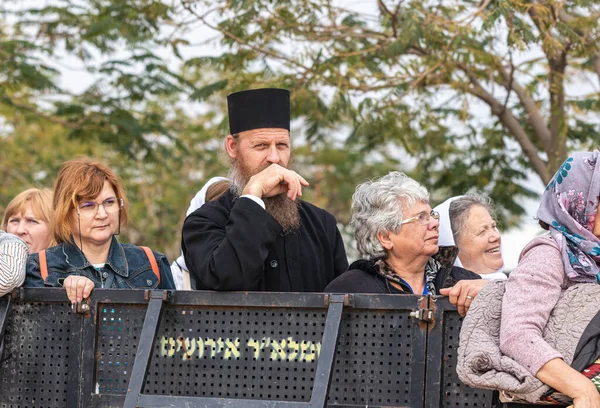 El sacerdote mira desde detrás de la cerca de separación en la ceremonia bautismal en el Sitio Bautismal de Jesucristo cerca de Jericó en Israel — Foto de Stock