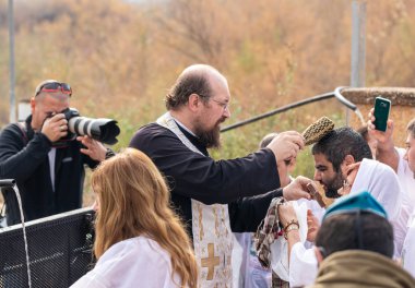 Jericho, İsrail, 18 Ocak 2020: Rahip, İsrail 'deki Jericho yakınlarındaki Ürdün Nehri üzerindeki İsa Mesih' in Vaftiz Alanı 'nda vaftiz törenini gerçekleştiriyor.