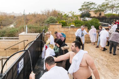 Jericho, İsrail, 18 Ocak 2020: Epifani Ayinine katılan inananlar İsrail 'deki Jericho yakınlarındaki İsa' nın Vaftiz Alanındaki Ürdün Nehri 'nden kutsal su kullanıyorlar.