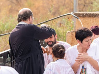 Jericho, İsrail, 18 Ocak 2020: Rahip, İsrail 'deki Jericho yakınlarındaki Ürdün Nehri üzerindeki İsa Mesih' in Vaftiz Alanı 'nda vaftiz törenini gerçekleştiriyor.