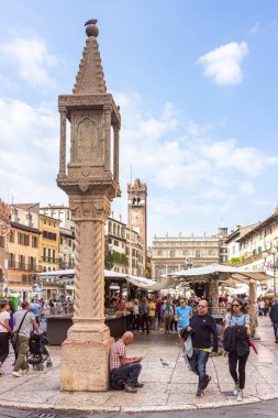 Verona, İtalya - 26 Eylül 2015: Bulutlu bir günde Piazza Delle Erbe meydanında yürüyen turistler, onu inceleyip, İtalya 'nın Verona kentinde geçmişiyle ilgili fotoğraflar çekiyorlar.