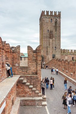Verona, İtalya - 27 Eylül 2015: Bulutlu bir günde Ponte Scaligero köprüsü boyunca yürüyen turistler, Verona, İtalya 'da inceleyin ve fotoğraf çekin.