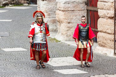 Verona, İtalya, 27 Eylül 2015: Roma lejyonerleri gibi giyinmiş iki adam İtalya 'nın Verona kentindeki Arena yakınlarındaki Piazza Bra meydanında yürüyor