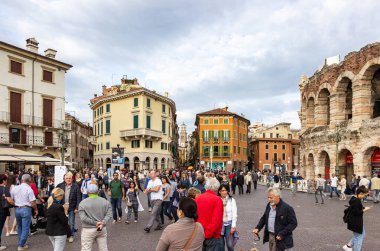 Verona, İtalya - 26 Eylül 2015: Piazza Sütyen Meydanı 'nda yürüyen turistler, Arena' yı teftiş ediyor ve İtalya 'nın Verona kentindeki geçmişiyle karşılaştırma yapıyorlar..