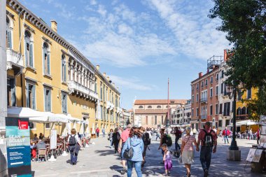 Venedik, İtalya - 28 Eylül 2015: Venedik sokakları. Mavi ceketli kadın Venedik, İtalya 'da bir kanal üzerindeki Ponte Giustinian köprüsünde duruyor..