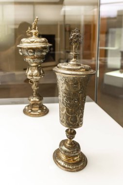 Milan, İtalya, 29 Eylül 2015: Dekoratif, İtalya 'nın Milano kentindeki Sforzesco Şatosu' nun müzesinde sergilenen büyük metal altın kadehler yerleştirdi.