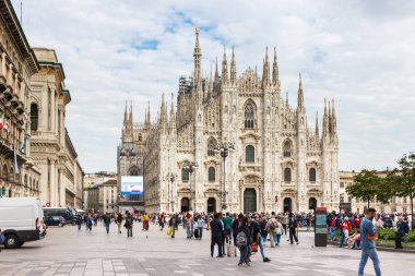 Milan, İtalya - 29 Eylül 2015: Milano, İtalya 'da Milano Katedrali' nin önündeki Piazza del Duome Meydanı boyunca çok sayıda turist ve gezgin yürüyor.