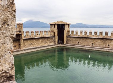 Sirmione, İtalya - 01 Ekim 2015: Lombardy, Kuzey İtalya Sirmione kasabasındaki Castello Scaligero kalesinin güçlendirilmiş iç limanı