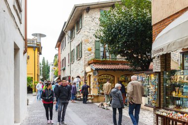 Sirmione, İtalya, 01 Ekim 2015: Turistler ve vatandaşlar İtalya 'nın kuzeyindeki Lombardy Sirmione kasabasının eski bir bölümünde Vittorio Emanuele Caddesi boyunca yürüyorlar