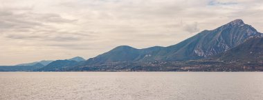 Doğa, bulutlardaki dağlar ve Kuzey İtalya 'daki Lombardiya Sirmione kasabası yakınlarındaki Garda Gölü etrafındaki yerleşim yerleri.