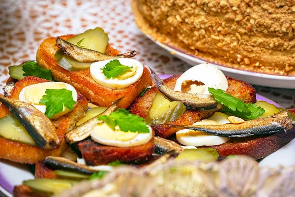 Sandwiches with smoked sprats, boiled egg, pickles and parsley on a plate — Stock Image Sandwiches with smoked sprats, boiled egg, pickles and parsley on a plate Stock Photo