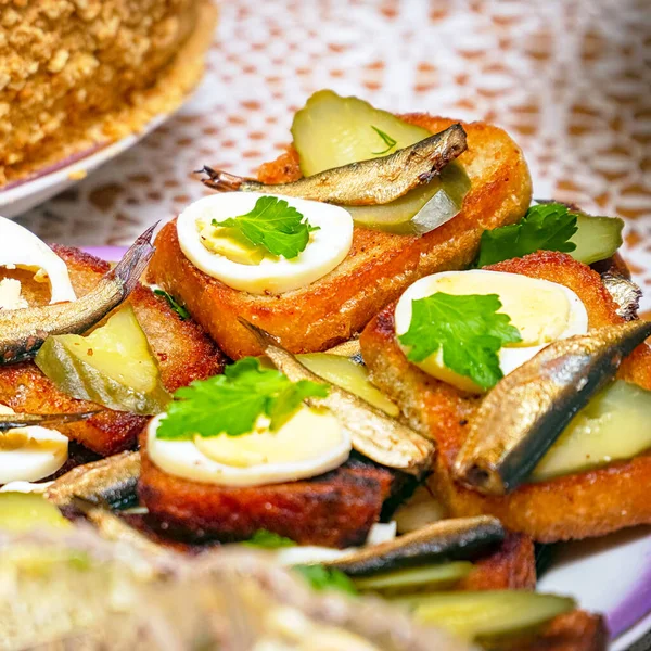 Sandwiches with smoked sprats, boiled egg, pickles and parsley on a plate. Selective focus — Stock Image Sandwiches Smoked Sprats Boiled Egg Pickles Parsley Plate Selective Focus Royalty Free Stock Images