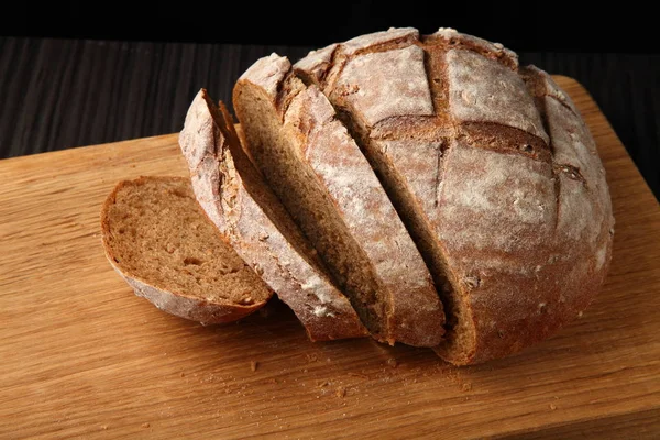 Brot, geschnitten auf einem Eichenbrett — Stockfoto