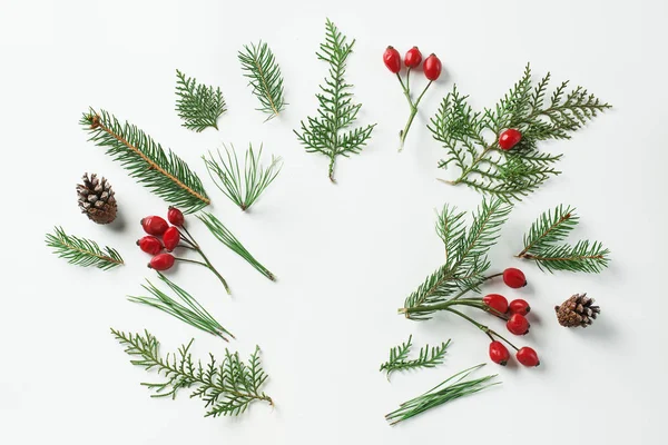 Diseño de maqueta creativa hecha de árbol de navidad y ramas de bayas de acebo rojo con espacio de copia en blanco. Concepto casero plano laico —  Fotos de Stock