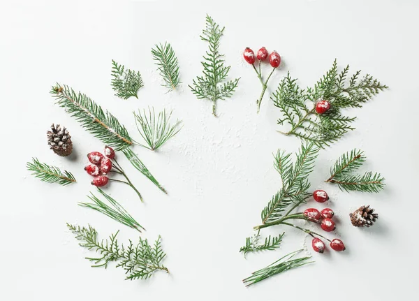 Kreativa mockup layout gjord av julgran och röda snöiga holly bär grenar med kopia utrymme på vitt. Hemmagjord platt lekmanna-konceptet — Stockfoto