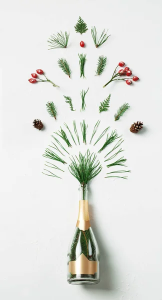 Botella de champán con follaje de salpicadura de invierno sobre fondo blanco. Acostado. Concepto del partido . —  Fotos de Stock