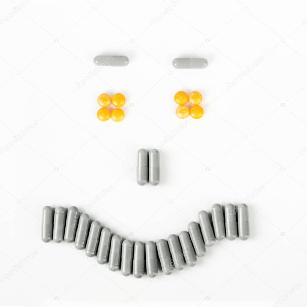 Happy smile made from many pills and capsules. wellness concept