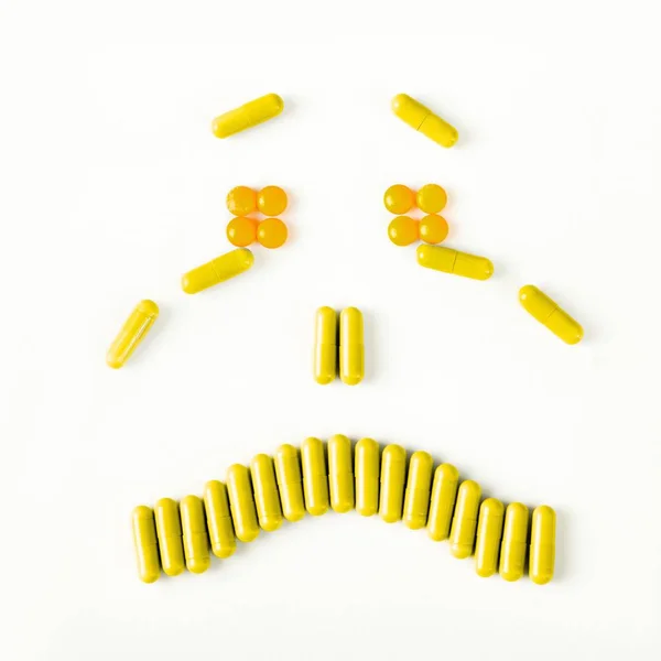 Sad and crying smile made from many pills capsules. wellness concept — Stock Photo, Image