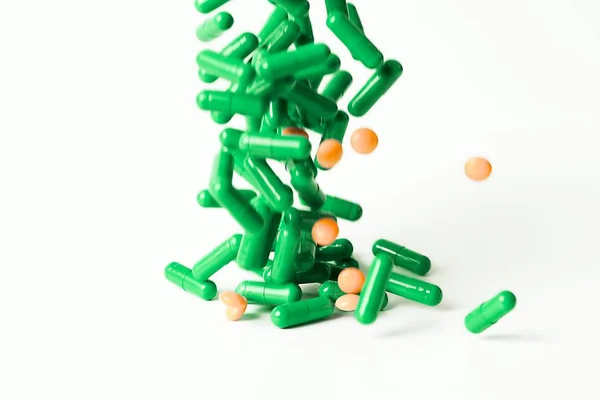 Laissant tomber une poignée de pilules médicinales isolées sur fond blanc — Photo