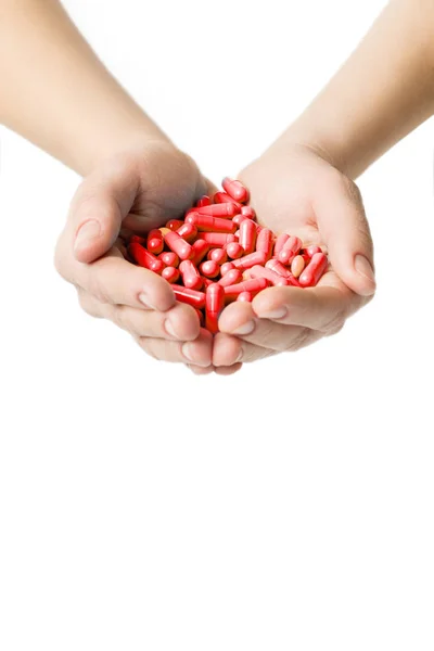 Ręce daje czerwone kapsułki i tabletki pomarańczowy na białym tle. — Zdjęcie stockowe