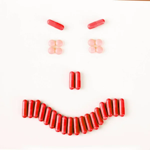 Злая улыбка сделанная из многих таблеток и капсул. Концепция здоровья — стоковое фото