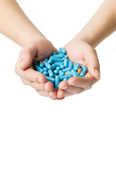 Hände geben blaue Kapseln und orangefarbene Pillen auf weißem Hintergrund. — Stockfoto