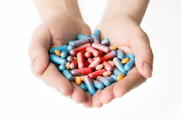 Capsuled niebieskie tabletki czerwony ból w rękach człowieka — Zdjęcie stockowe