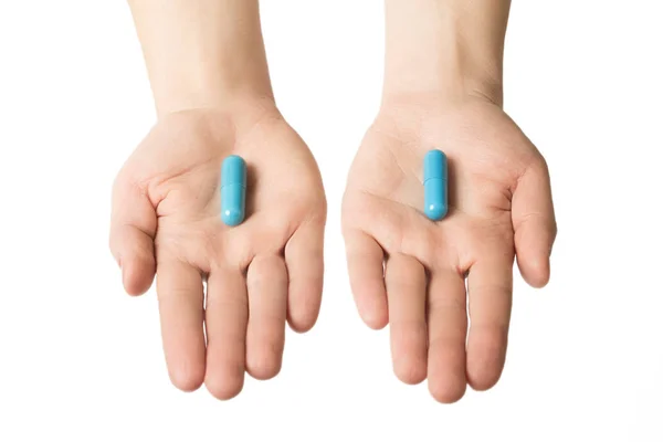 Мужские руки дают две большие голубые таблетки. Делай свой выбор. Успокаивающие нервы — стоковое фото