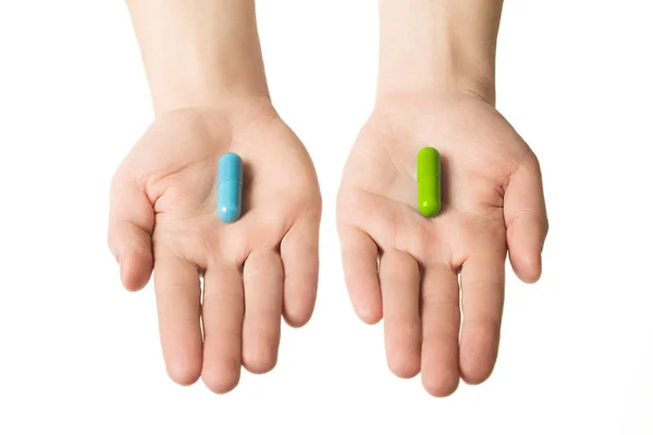 Мужские руки дают две большие таблетки. Синий и зеленый. Выбирай. спокойные нервы и здоровье. Выберите свою сторону — стоковое фото