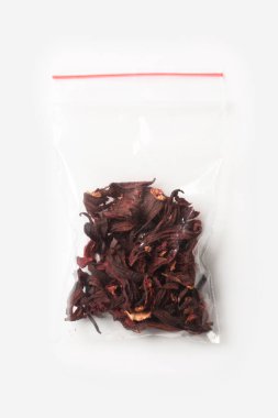 Plastik şeffaf fermuar çanta ile beyaz, vakum paket mockup kırmızı Klipsli izole yarım carcade çay. Kavramı.
