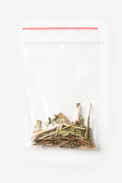 Bolsa de cremallera transparente de plástico con un poco de té Sally en flor aislado en blanco, maqueta de paquete de vacío con clip rojo. Concepto . — Foto de Stock