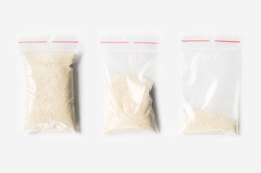 Üç boş, yarım ve tam plastik şeffaf fermuarlı torba kuru ham buğday irmik üzerine beyaz izole kümesi. Vakumlu paket mockup kırmızı Klipsli. Kavramı.
