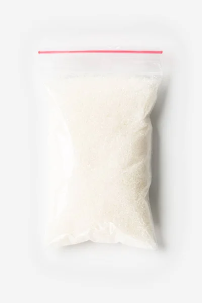 Plastic transparent zipper bag with full Granulated sugar isolated on white, Vacuum package mockup with red clip. Concept. — Stock Photo, Image