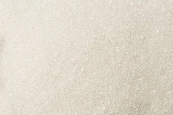 Granulated white textured Sugar sand as background.