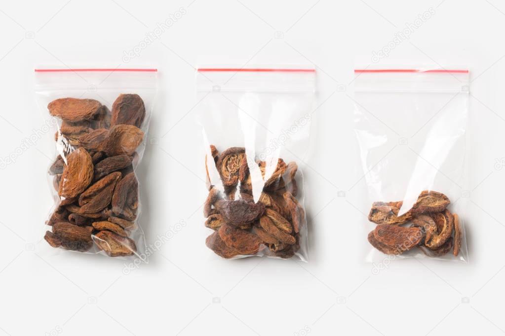 Set of three EMPTY, HALF AND FULL Plastic transparent zipper bag with home dried apricots isolated on white. Vacuum package mockup with red clip. Concept.