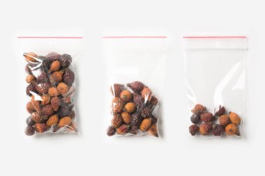 Üç boş, yarım ve tam plastik şeffaf fermuar çanta üzerinde beyaz izole ev kurutulmuş briar kümesi. Vakumlu paket mockup kırmızı Klipsli. Kavramı.