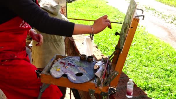 Pintura de artista paisagista em óleos misturados nos circuitos de saída da paleta pincel de pintura — Vídeo de Stock