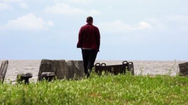 Adam kazak ve pantolon rüzgarlı yaz havalarda mesire iskele boyunca yürüyüş