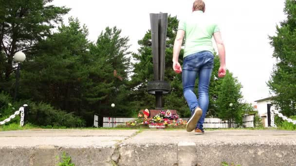 Due uomini si avvicinano all'obelisco, l'iniziato eterno ricordo dei suoi connazionali, morti nelle battaglie per la Patria con i nazisti — Video Stock